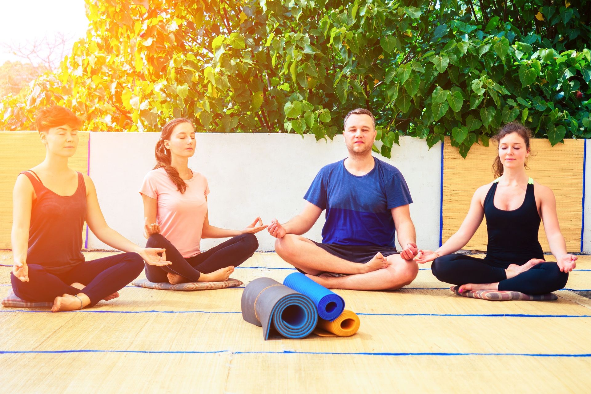 a group of beautiful people meditate in a yoga class on the roof